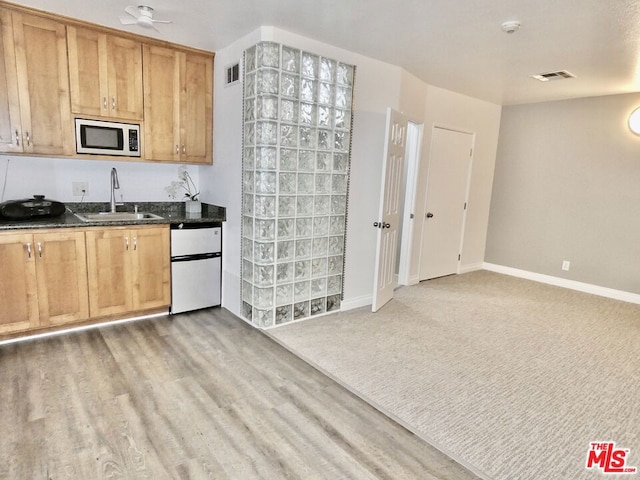 kitchen featuring light hardwood / wood-style flooring, sink, white microwave, and refrigerator