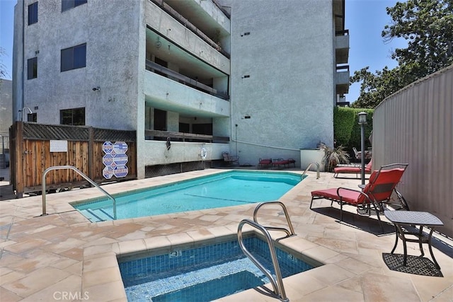 view of swimming pool featuring a community hot tub