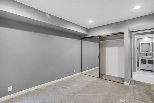 unfurnished bedroom with light colored carpet and a closet