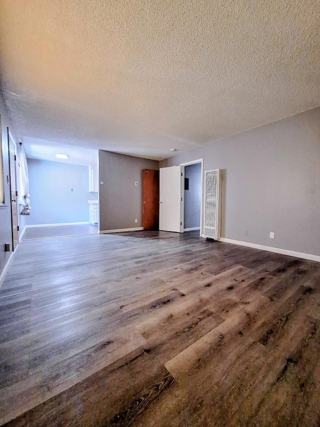 empty room with hardwood / wood-style floors and a textured ceiling