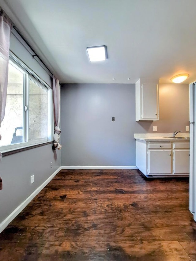 interior space featuring white cabinetry, sink, dark hardwood / wood-style floors, and white fridge