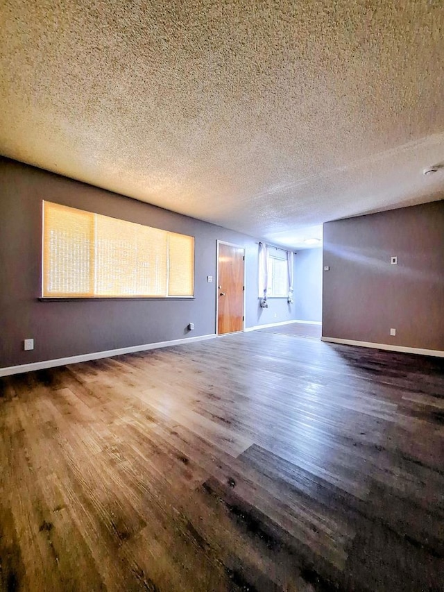 empty room featuring wood-type flooring and a textured ceiling