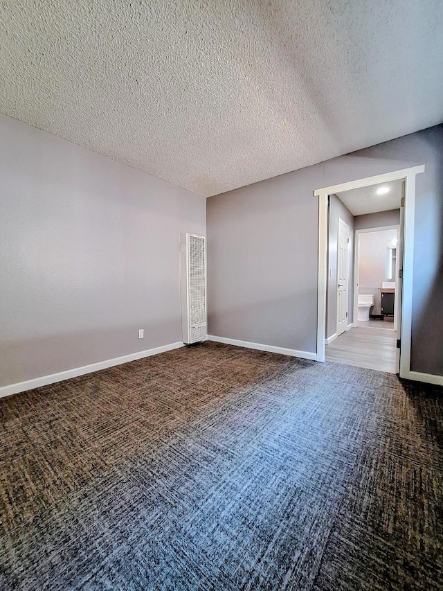 spare room with carpet flooring and a textured ceiling