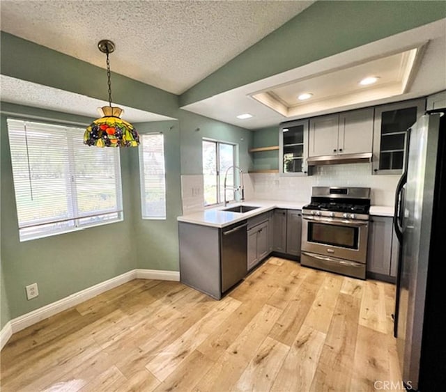 kitchen with sink, appliances with stainless steel finishes, gray cabinetry, a textured ceiling, and decorative light fixtures