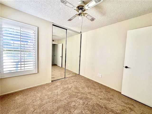 unfurnished bedroom featuring a textured ceiling, carpet floors, a closet, and ceiling fan