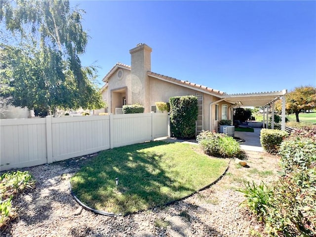 view of side of property featuring a yard and a pergola