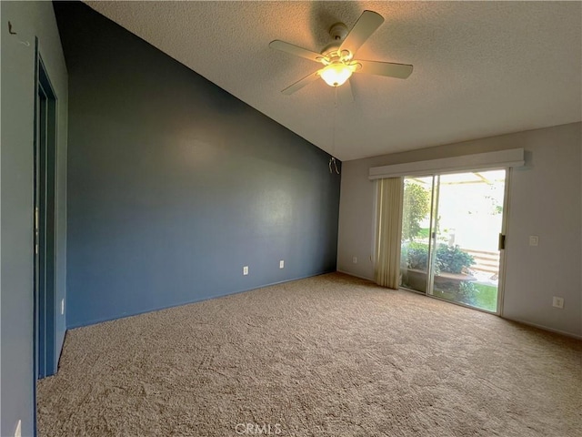 carpeted spare room with ceiling fan, vaulted ceiling, and a textured ceiling