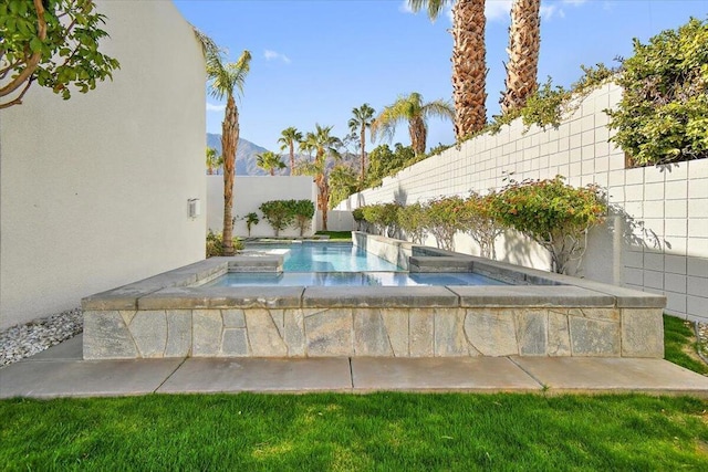 view of swimming pool with an in ground hot tub and a mountain view