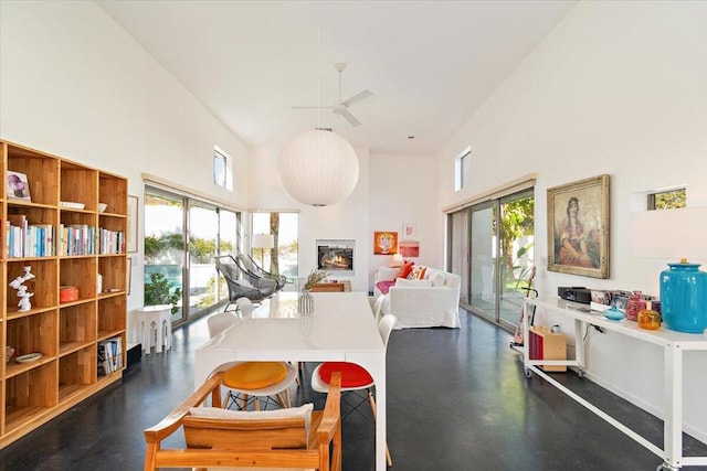 dining room featuring ceiling fan, a high ceiling, and a healthy amount of sunlight