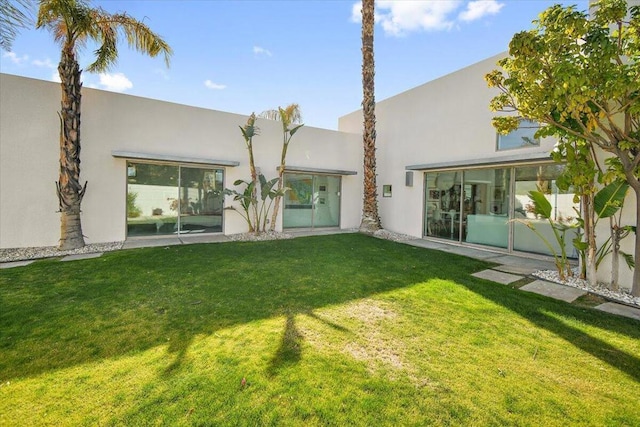 rear view of property featuring a lawn