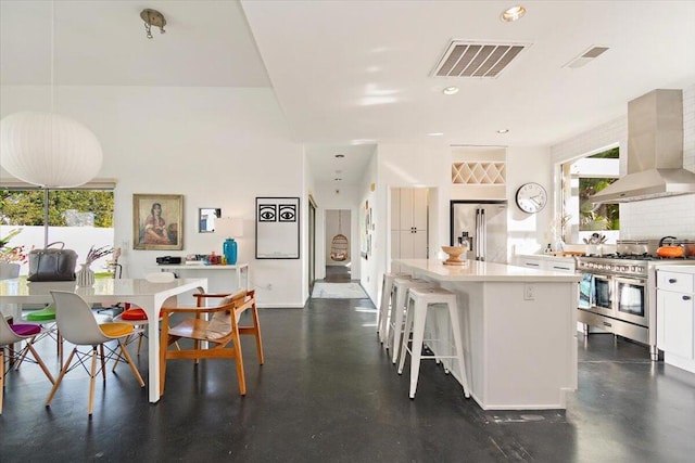 kitchen featuring white cabinets, a healthy amount of sunlight, a kitchen island, and high quality appliances