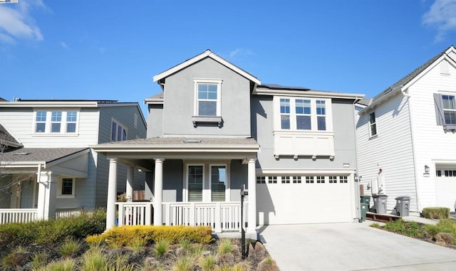 view of front of home with a garage, solar panels, and a porch