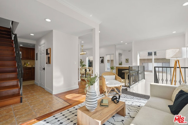 living room with ornamental molding and light tile patterned flooring