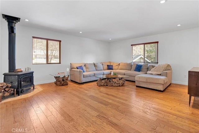 living room featuring a wood stove and light hardwood / wood-style flooring