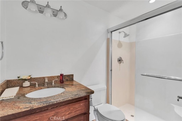 bathroom featuring toilet, an enclosed shower, and vanity