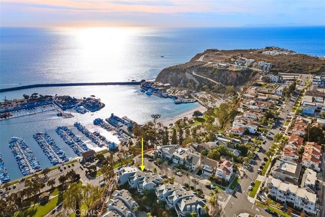 aerial view at dusk featuring a water view