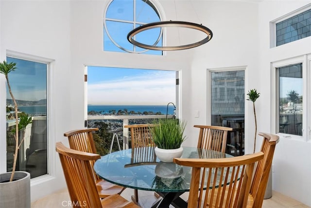 interior space featuring plenty of natural light, a water view, and a high ceiling