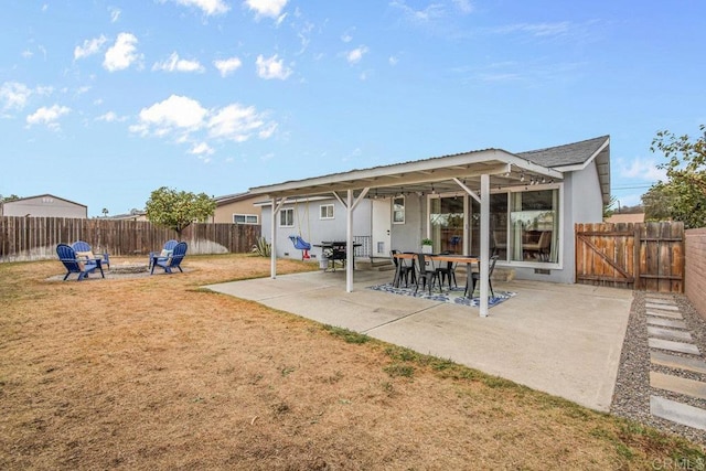 rear view of property with a patio and an outdoor fire pit