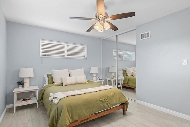 bedroom with ceiling fan, wood-type flooring, and a closet