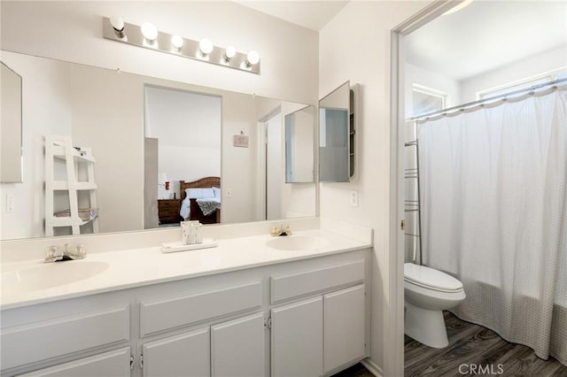 bathroom with wood-type flooring, toilet, and vanity