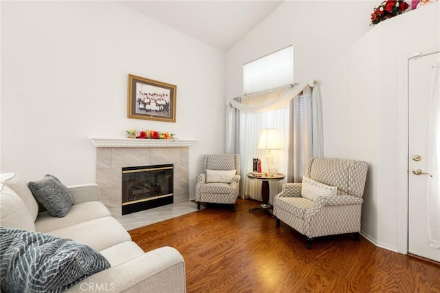 sitting room featuring vaulted ceiling, hardwood / wood-style floors, and a fireplace