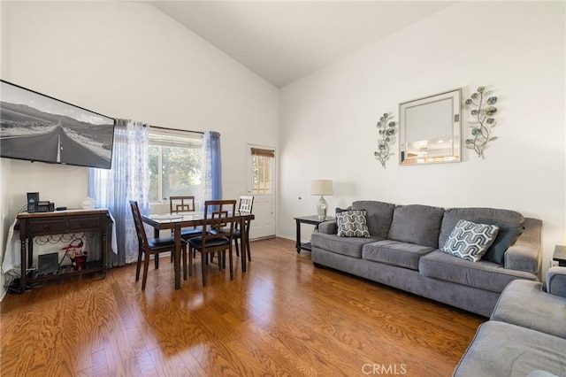 living room with hardwood / wood-style floors and high vaulted ceiling