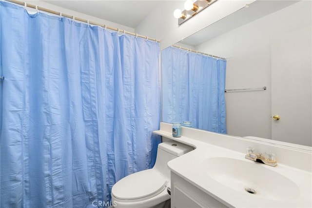 bathroom featuring toilet, a shower with shower curtain, and vanity