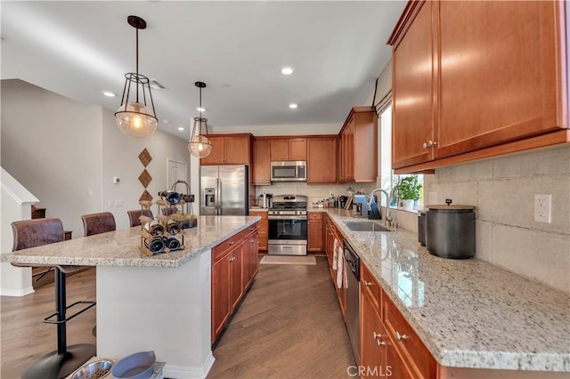 kitchen featuring sink, appliances with stainless steel finishes, a breakfast bar area, and a kitchen island