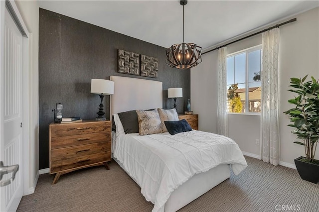 carpeted bedroom featuring an inviting chandelier