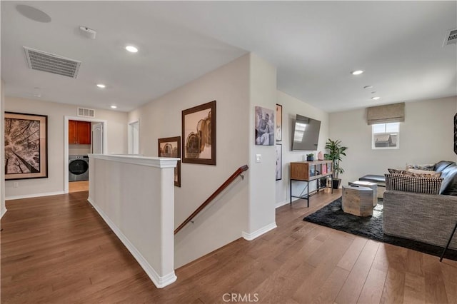 corridor featuring hardwood / wood-style flooring and washer / dryer