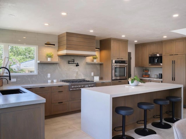 kitchen with a center island, stainless steel appliances, tasteful backsplash, sink, and a kitchen breakfast bar