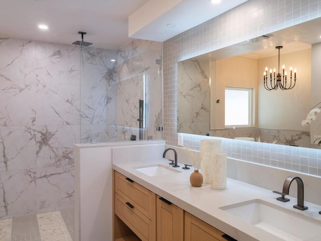 bathroom with vanity, tiled shower, a notable chandelier, and tile walls