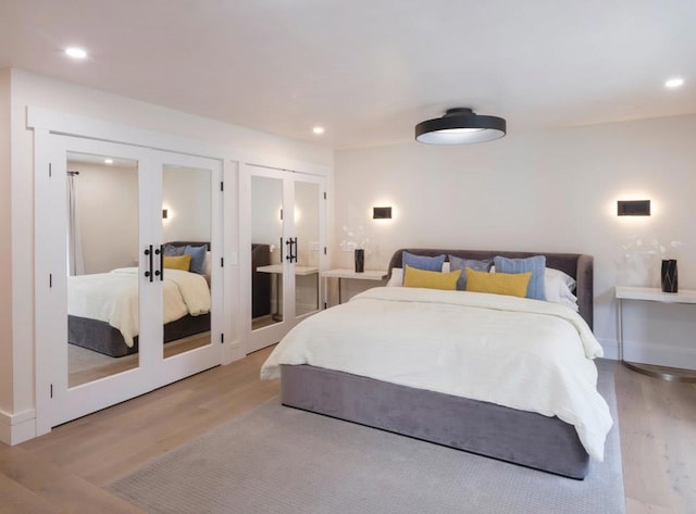 bedroom featuring french doors and light hardwood / wood-style flooring