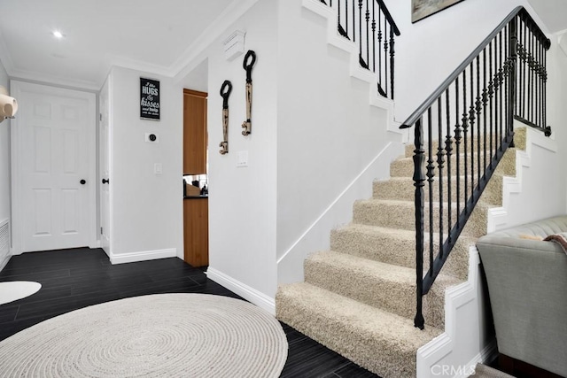 stairway with crown molding and wood-type flooring