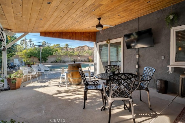 view of patio / terrace with ceiling fan and a fenced in pool