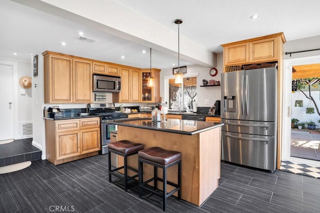 kitchen featuring hanging light fixtures, stainless steel appliances, a center island, and a breakfast bar