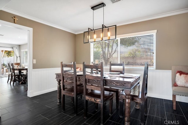 dining area with ornamental molding and an inviting chandelier