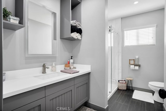 bathroom featuring vanity, toilet, and a shower with shower door