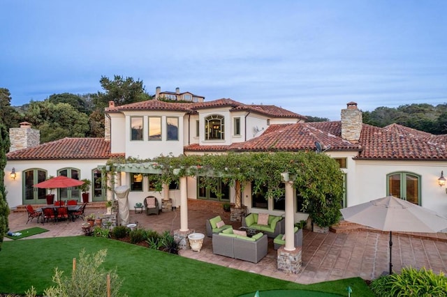 back of property with a patio, a lawn, and an outdoor hangout area