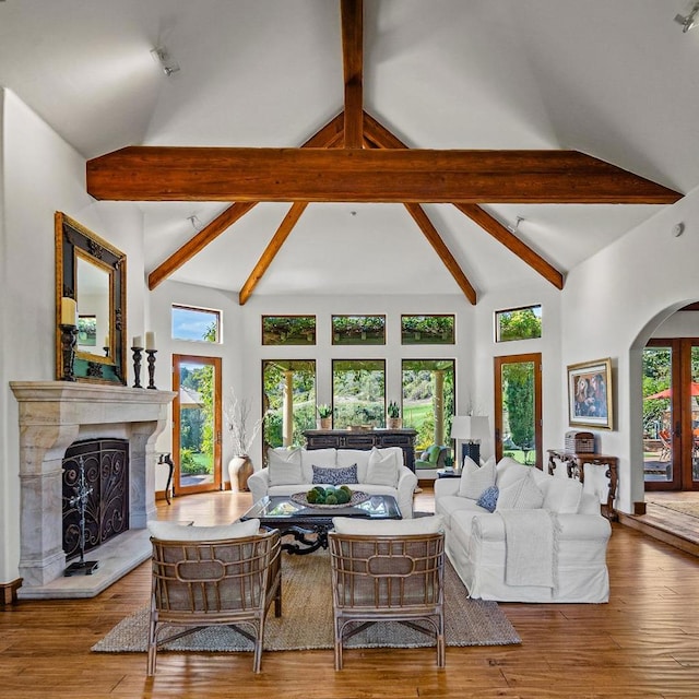 living room with a wealth of natural light, hardwood / wood-style floors, and high vaulted ceiling