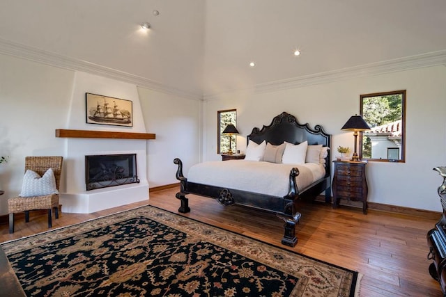 bedroom with a fireplace, hardwood / wood-style floors, and ornamental molding