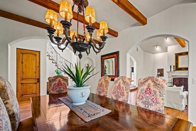 dining room with hardwood / wood-style floors, beam ceiling, and a chandelier