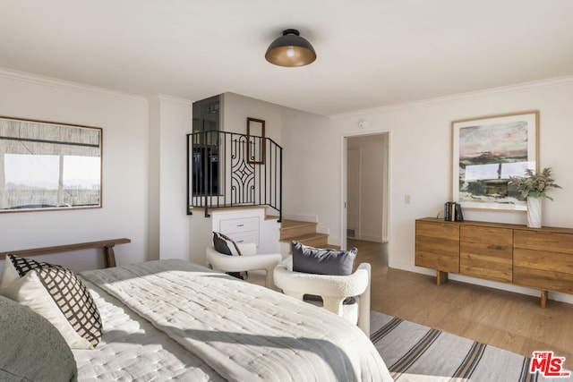 bedroom featuring ornamental molding and light hardwood / wood-style floors