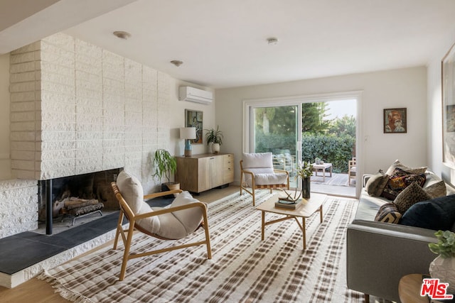 living room featuring hardwood / wood-style floors, a wall mounted AC, and a fireplace