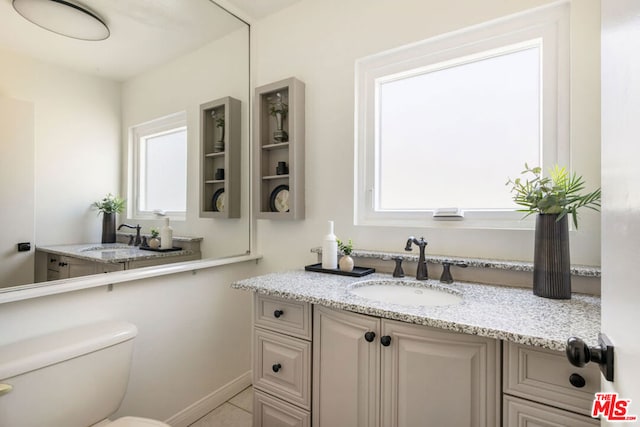 bathroom with vanity, tile patterned flooring, and toilet