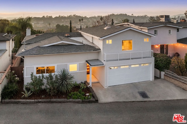 view of front facade featuring a balcony, a garage, and central AC unit