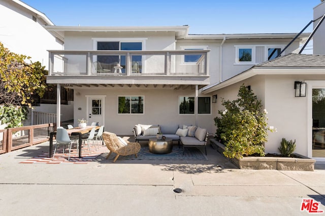 exterior space featuring a balcony, an outdoor hangout area, and a patio area