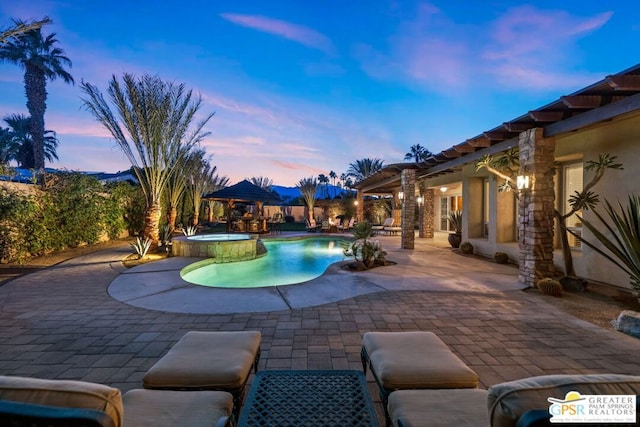 pool at dusk featuring a patio area and a gazebo