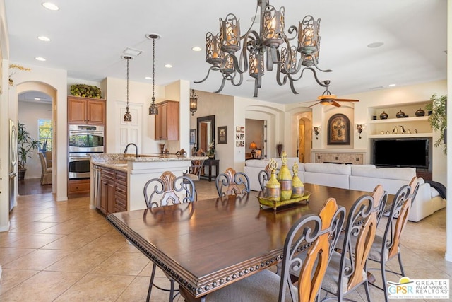 tiled dining room featuring built in features and ceiling fan with notable chandelier