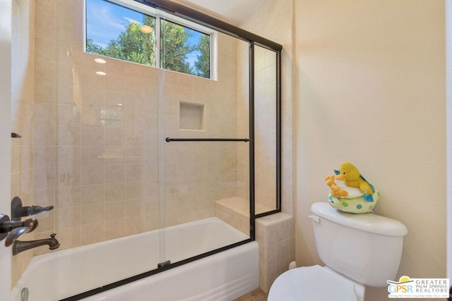 bathroom featuring enclosed tub / shower combo and toilet